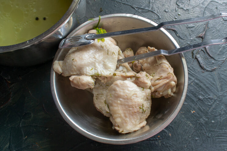 Finished boiled chicken Boiled chicken thighs resting in a metal bowl.