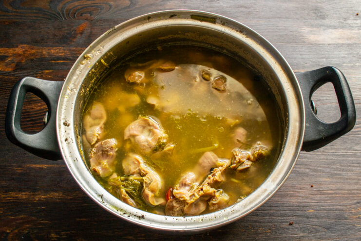 Prepping the gizzards Simmering chicken gizzards with aromatics in a pot