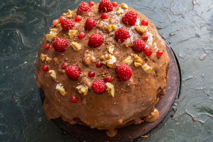 Decorating the Cake Top of a chocolate cake with raspberries and nuts