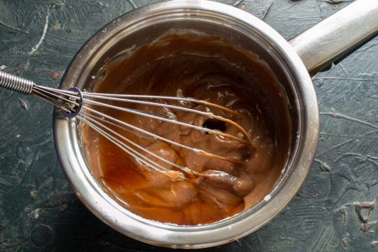 Flavoring the Cream Pouring liqueur into chocolate cream