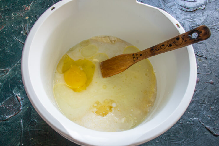 Adding The Oil Pouring refined neutral oil into the mixing bowl with the batter