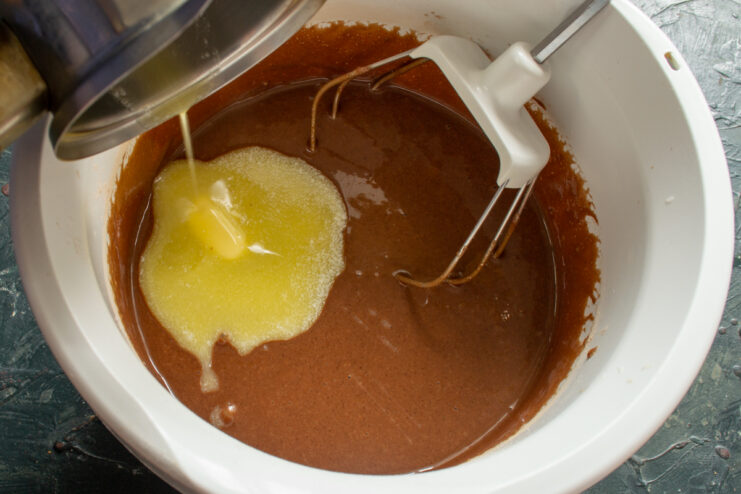 Adding the Butter Pouring melted butter into chocolate batter