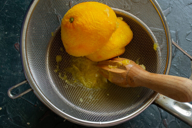 Making the juice Squeezing fresh orange juice using a wooden citrus reamer