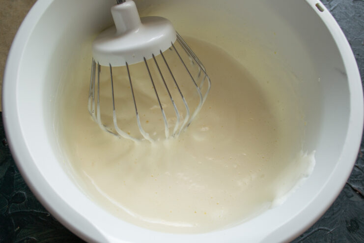 Whipping eggs and sugar Thick and fluffy whipped egg and sugar mixture in a bowl