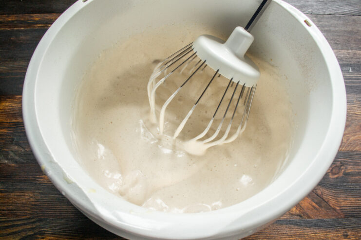 Whipping the egg mixture Thick and fluffy whipped egg mixture inside a mixer bowl.