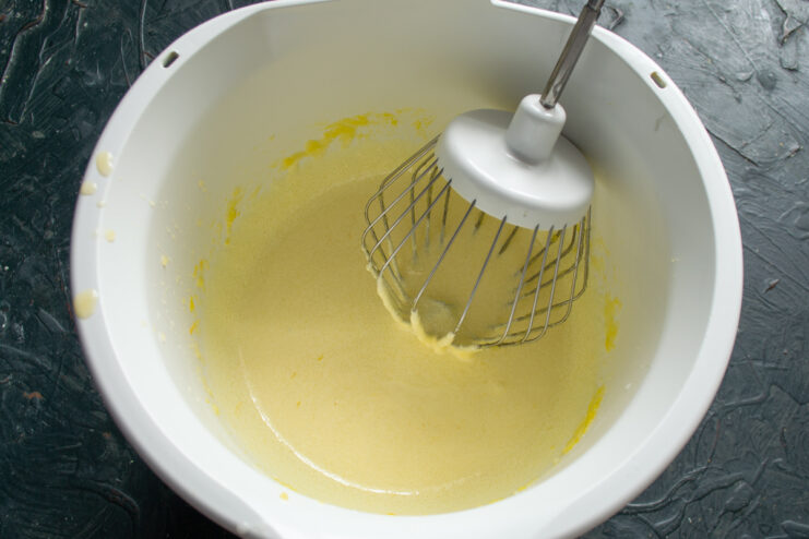 Whisking The Egg Mixture Whisked egg yolks and butter mixture in a bowl