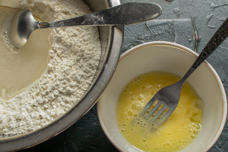 Whisking a chicken egg with a fork in a small bowl