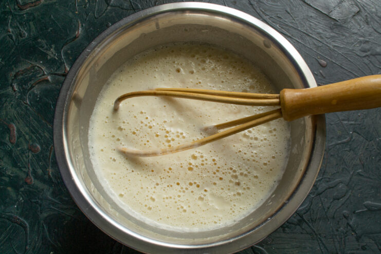 Preparing batter with egg whites and milk Mixing egg whites and room-temperature milk for crepe batter