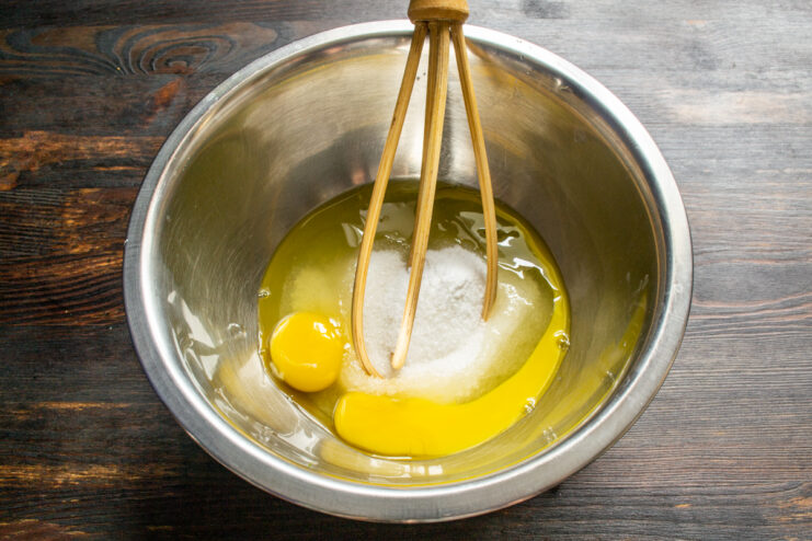 Whisking eggs and sugar together Whisking fresh eggs and sugar in a large metal mixing bowl