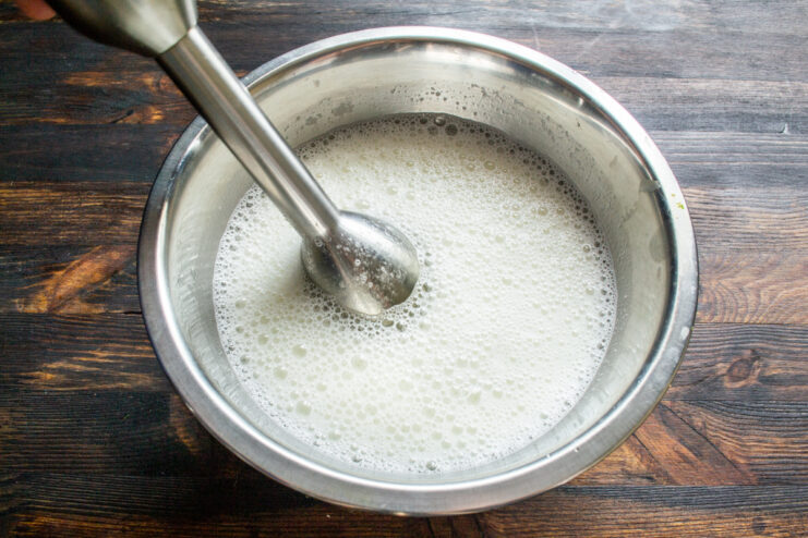 Blending the batter liquids Blending wet ingredients for crepe batter in a metal bowl