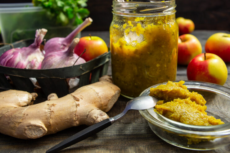 Apple sauce with ginger and garlic served in a glass jar and a small dipping bowl