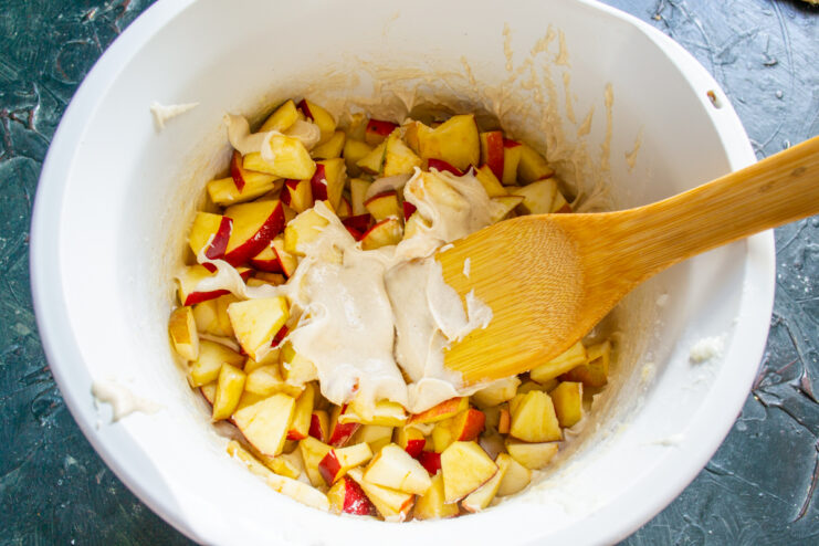 Combining batter and apples Diced apples added into the bowl of cake batter