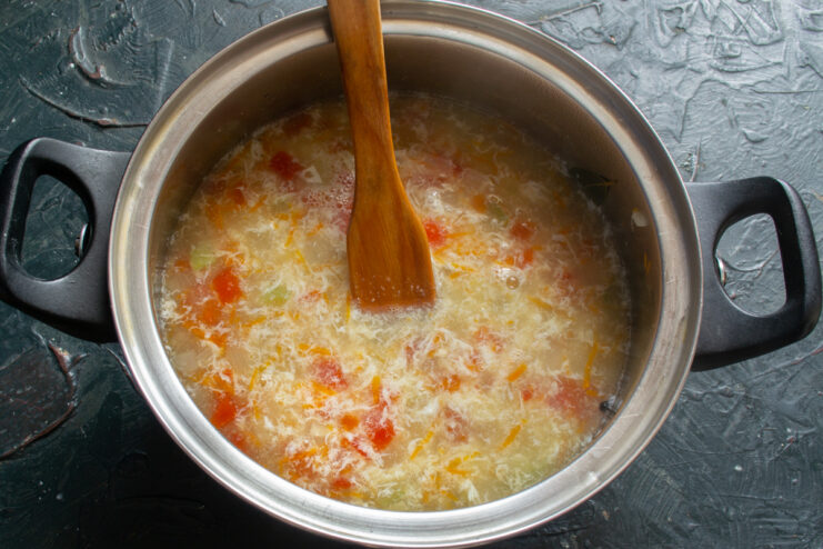 Stirring the Egg Into the Soup Egg ribbons floating in a pot of hot fish soup