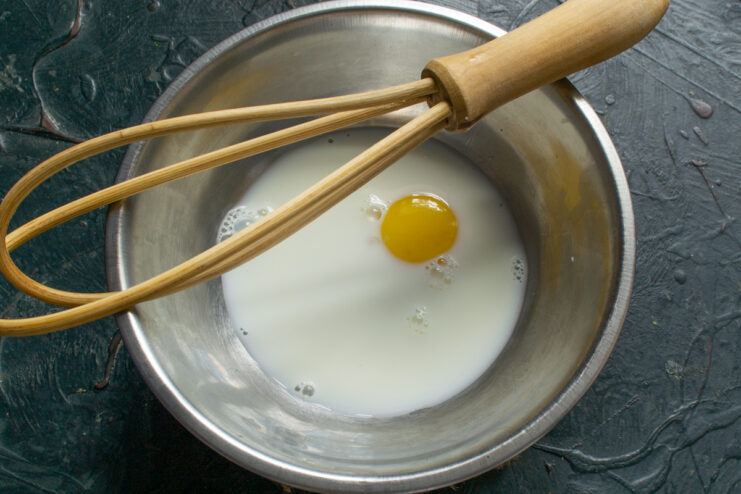 Mixing egg yolks with cream Whisking egg yolks together with cream in a bowl