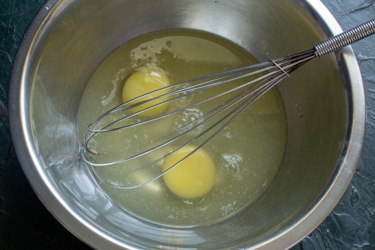 Prepping wet ingredients Whisking eggs and buttermilk together in a metal mixing bowl