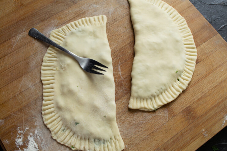 Crimping the Edges Crimping the edges of the khachapuri with a fork