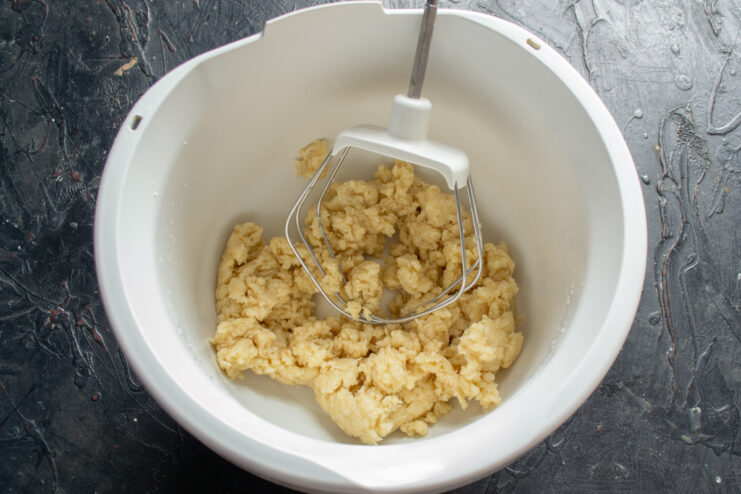Resting the kneaded dough Thick kneaded dough resting in a stand mixer bowl.
