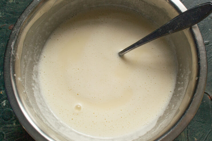 Mixing The Crepe Batter Whisking crepe batter ingredients in a metal mixing bowl