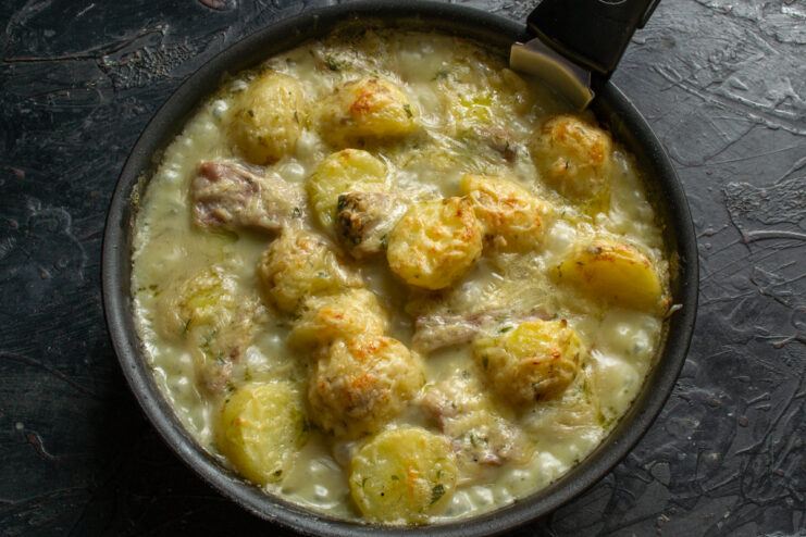 Baking until golden Baked potatoes and ribs with a melted cheese crust