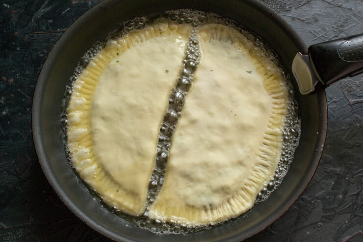 Frying the Khachapuri Frying two khachapuri in hot oil in a skillet
