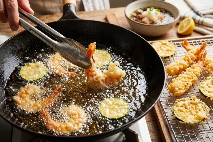 Deep-Frying Tempura Process Shrimp and vegetables frying in hot oil inside a wok to create a crispy tempura shell