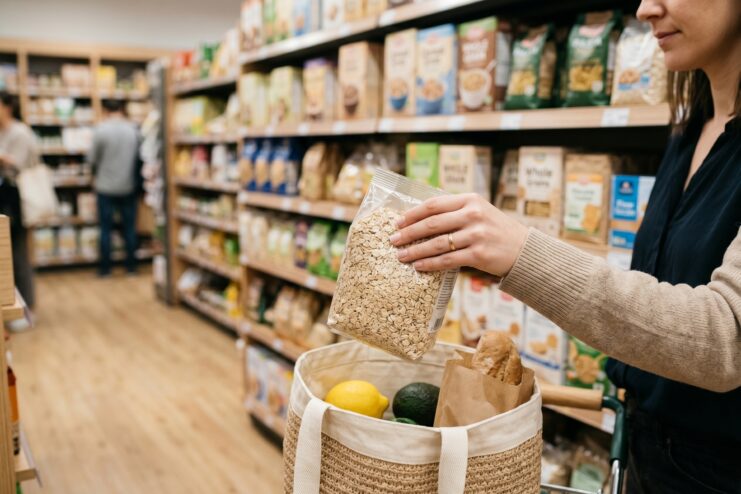 Choosing Grains in the Store Woman selecting a package of oatmeal in the grocery aisle of a supermarket.