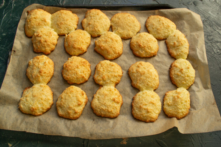 Baked cookies Golden brown coconut cookies resting on a baking sheet