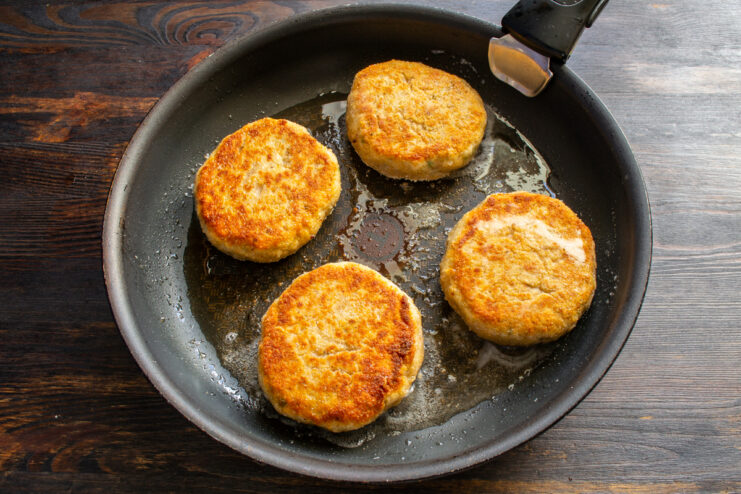 Golden brown crust Golden-brown fried chicken patties in a skillet