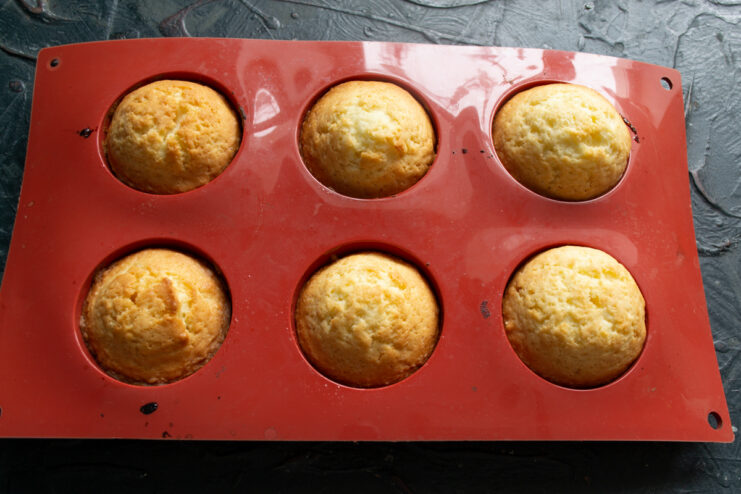 Baking to Golden Brown Freshly baked golden brown buns sitting in their baking molds