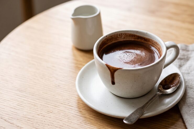 Perfectly Brewed Thick Cocoa Mug of thick hot cocoa with a light foam on a wooden surface