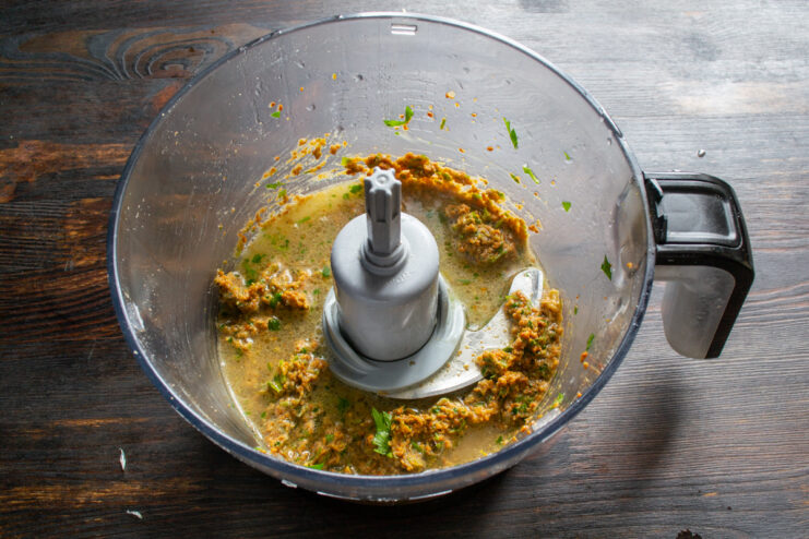 Thinning sauce with broth Pouring liquid chicken broth into a thick peanut paste