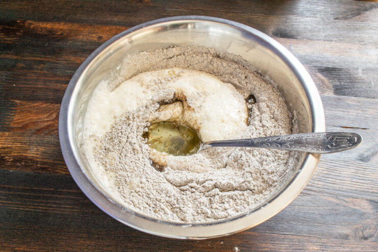 Pouring vegetable oil into the mixed rye bread dough