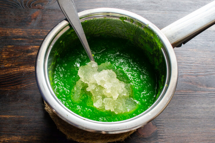 Mixing purée with gelatin Adding bloomed gelatin to hot green apple purée.