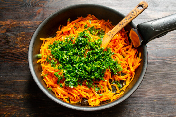 Adding Celery Adding chopped celery to sautéed carrots