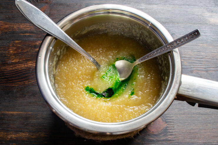Coloring the marmalade Stirring green food coloring into smooth apple purée.