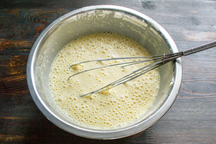 Resting The Batter Smooth rested crepe batter with small bubbles in a mixing bowl