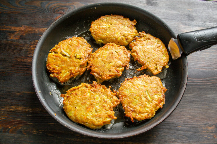 Cooked golden fritters resting in a skillet