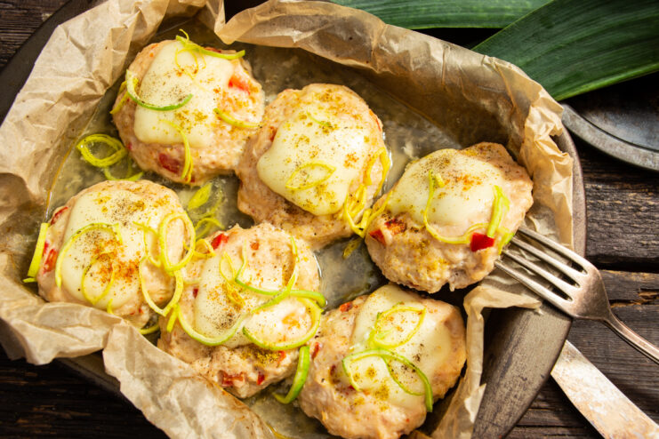 Finished juicy meatballs with pepper and mozzarella in a baking dish