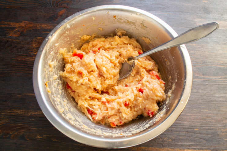 Kneading the meat mixture Mixed ground meat with pepper and cheese resting in a bowl