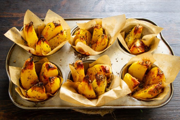 Fully baked golden potatoes resting in a muffin tin