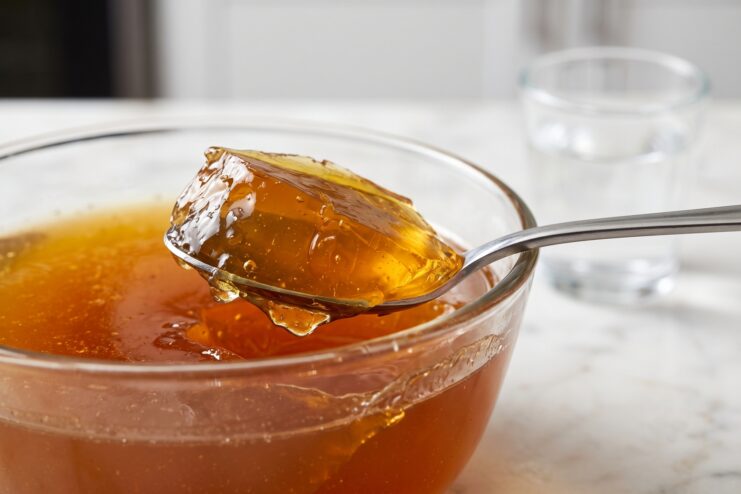 Colloidal Structure of Rich Bone Broth Thick chilled bone broth with a gelatinous texture resting in a spoon