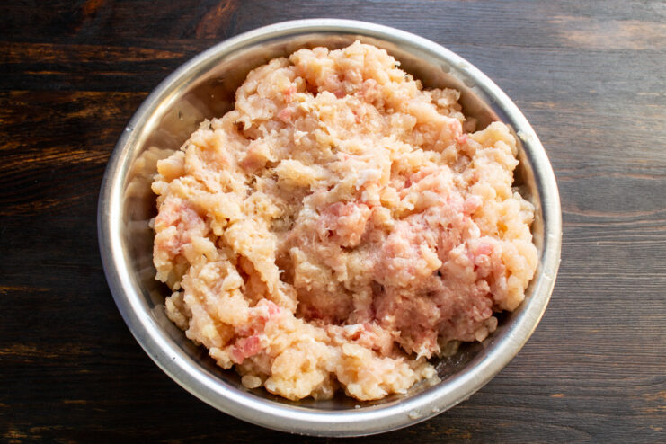 Chicken and pork meat mixture Ground chicken and pork meat inside a metal mixing bowl