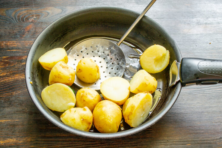Frying boiled new potatoes in a skillet with oil and butter
