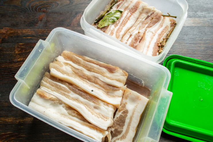 Sealed containers of curing pork belly ready for refrigerator aging
