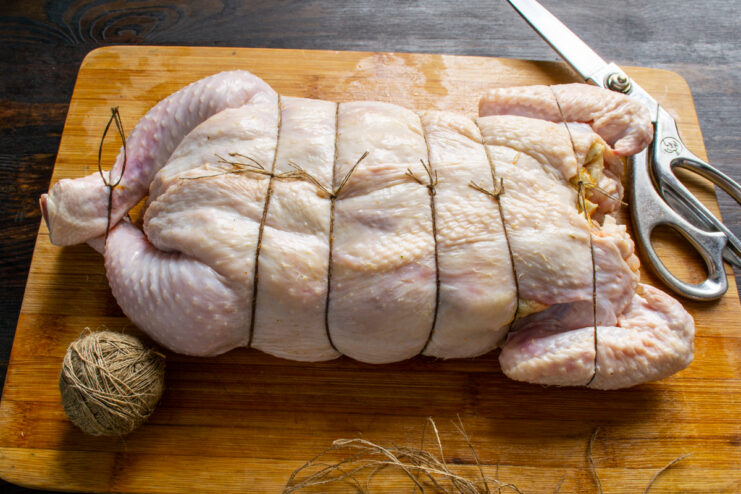 Stuffed chicken securely tied with kitchen twine.