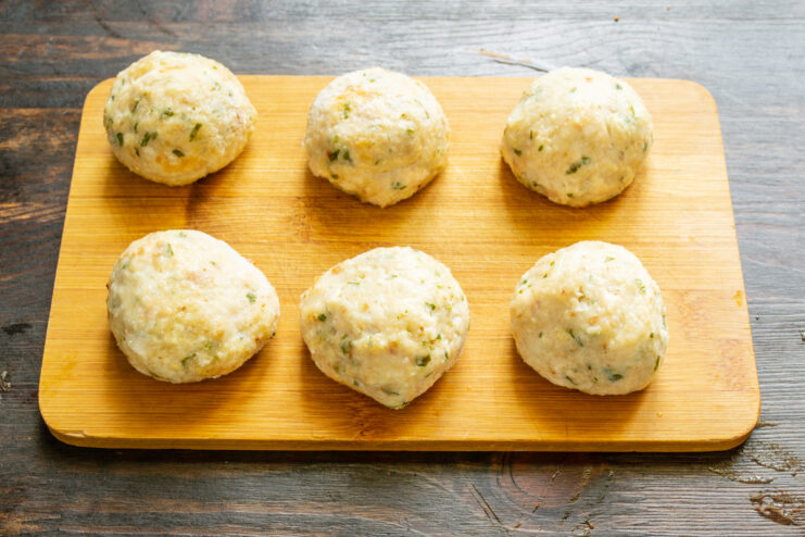 Chicken meatballs resting on a wooden cutting board