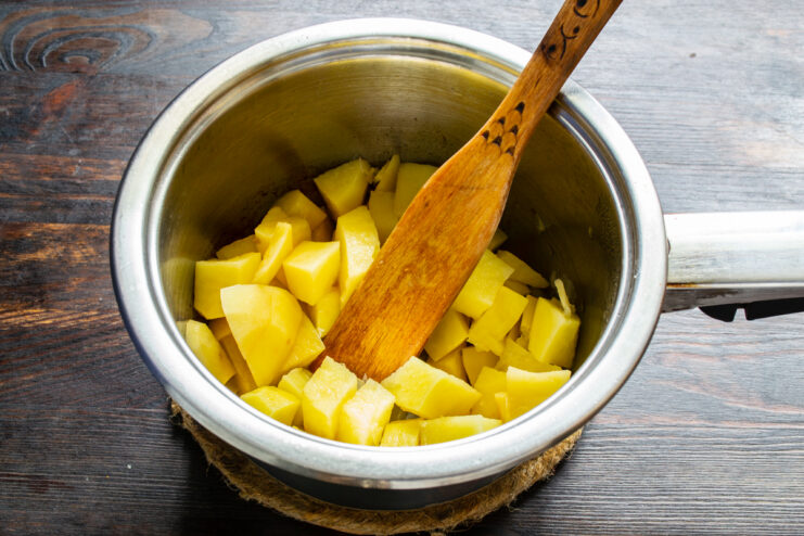 Adding potatoes Small potato cubes added to sautéed onions in a pot