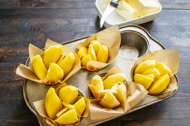 Placing small cubes of cold butter inside quartered potatoes
