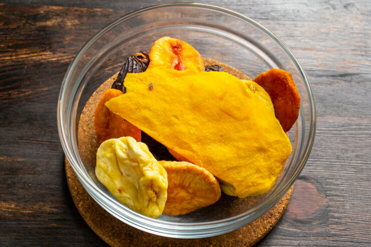 Adding dried mango Slices of dried mango on top of other dried fruits