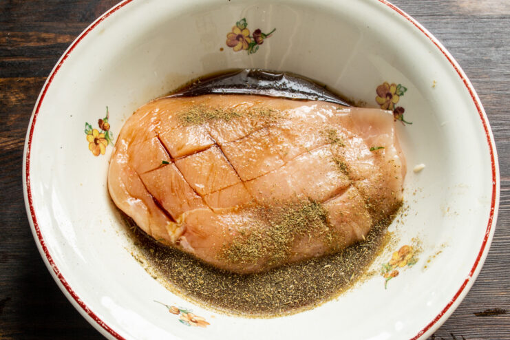 Marinating the chicken Raw chicken breast marinating in spices and soy sauce in a deep bowl